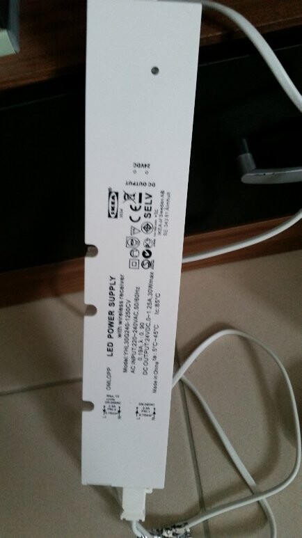 White LED power supply with label, cable lying nearby.