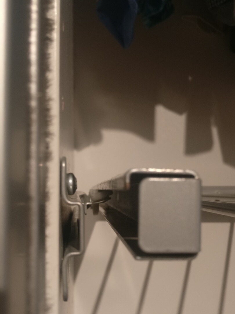 Close-up of a metal drawer slide with a square end piece.
