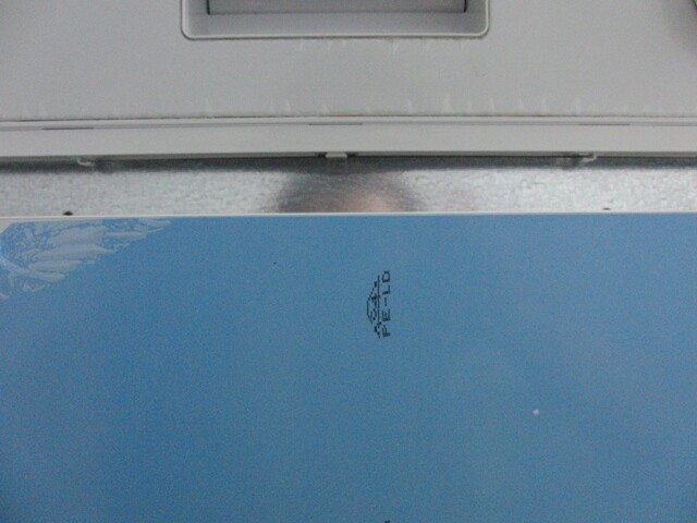 Close-up of a grey metal device on a blue surface with small text