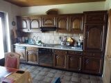 Kitchen with dark wooden cabinets, countertop, and table