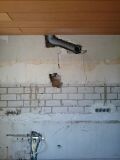 Unfinished construction site: visible piping in the wall area, construction work