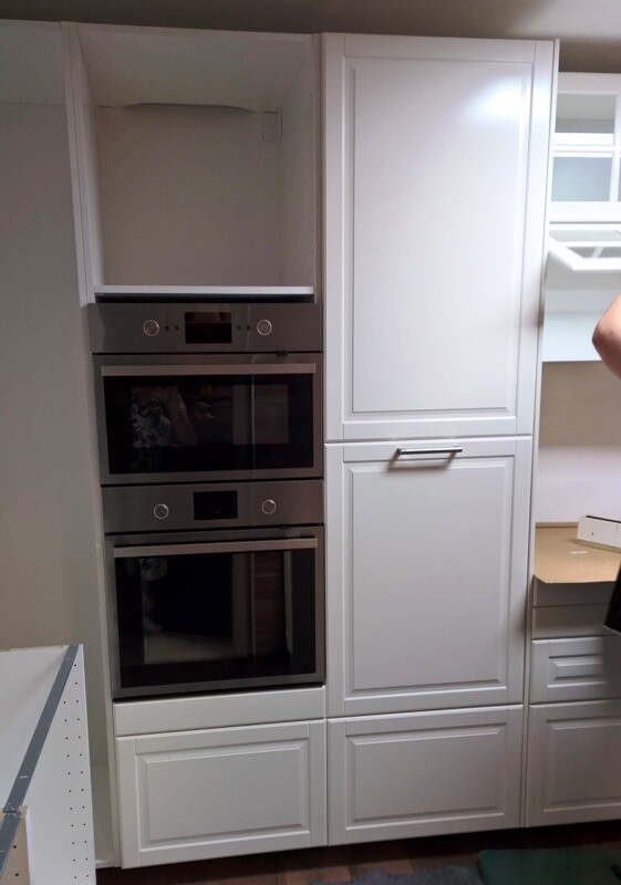 White kitchen units with two built-in ovens and closed cabinet elements.