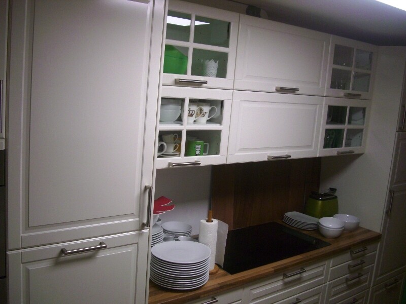 Kitchen with white wall cabinets, open dish rack, wooden countertop, and induction cooktop.