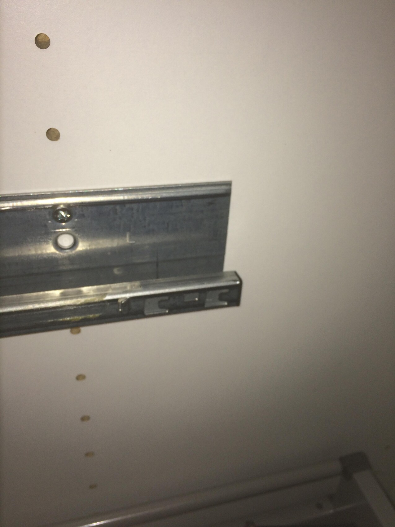 Metal drawer slide in a cabinet.
