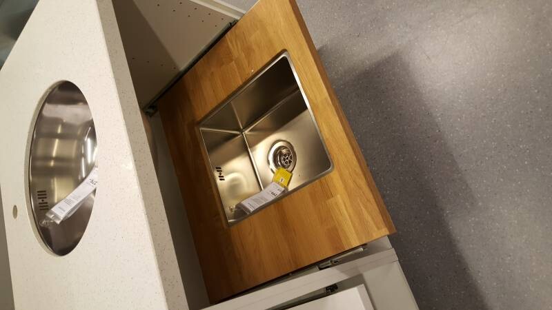 Kitchen island: wood countertop with built-in stainless steel sink; gray floor.