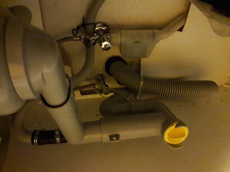 Under the sink, sanitary pipes and drain lines are visible.