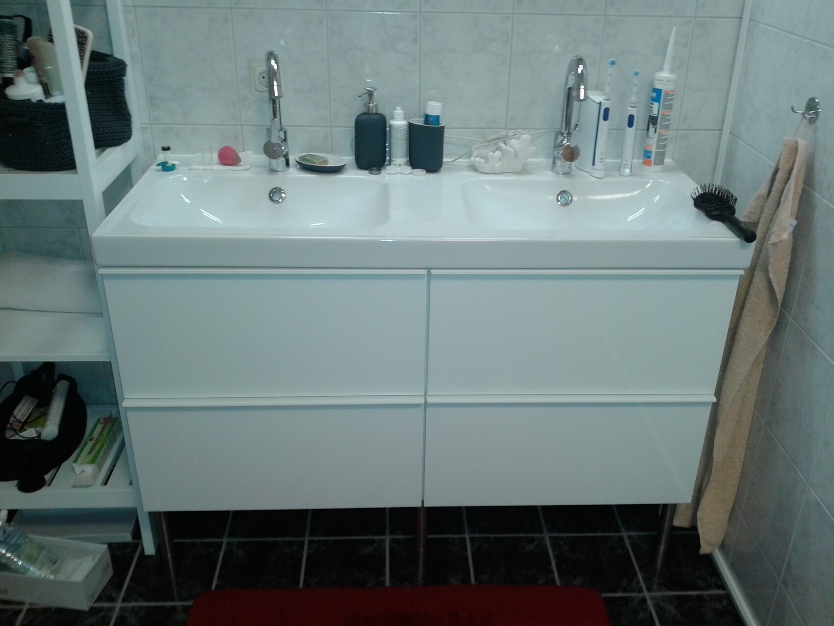 Double sink bathroom with white cabinets, faucets and toothbrushes