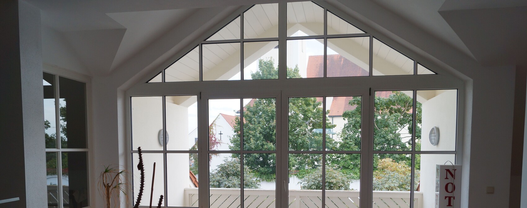 Large glass front in the living room with many windows and a door to the terrace