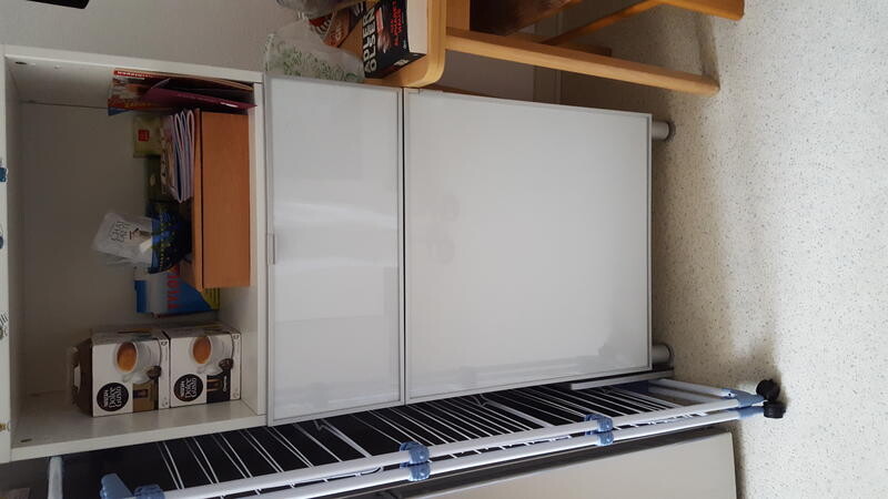 Storage room with white refrigerator, shelves, and storage boxes.