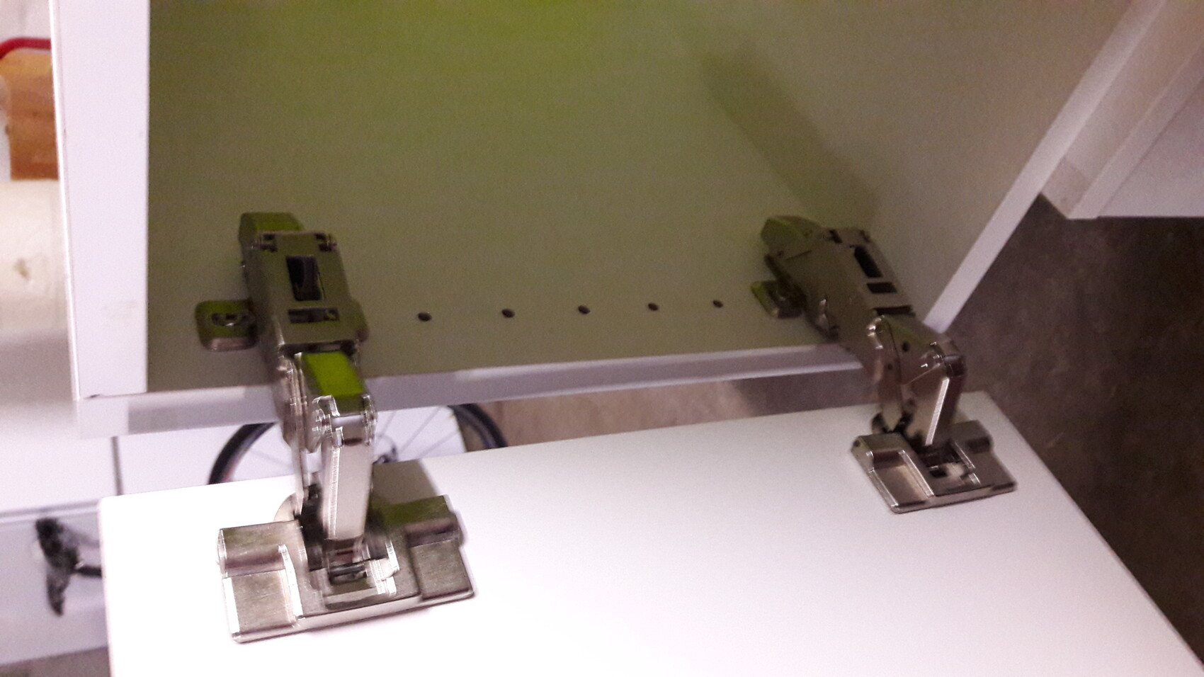 Hinge on kitchen cabinet, opened, visible metal fittings
