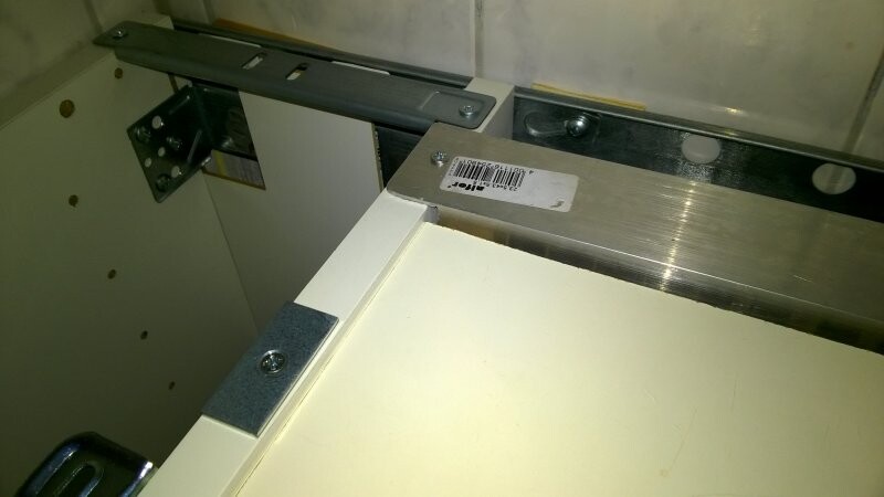 Close-up of a cabinet interior with metal rail, carcass, and barcode sticker