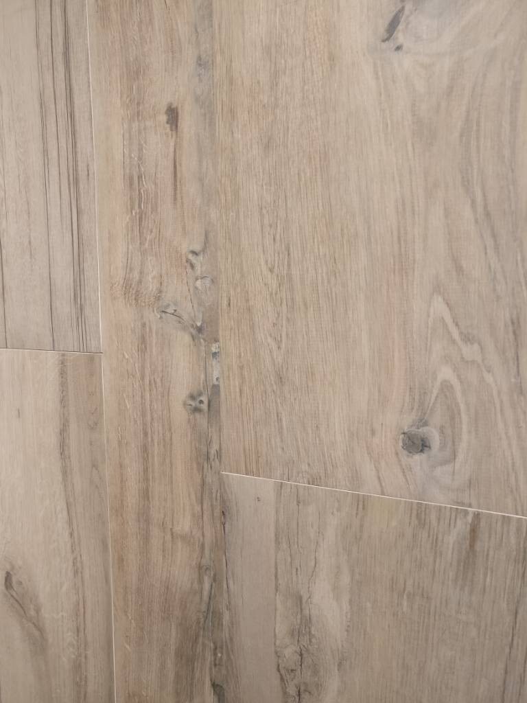 Heller Holzboden mit Holzplanken, sichtbare Maserung und Knoten.