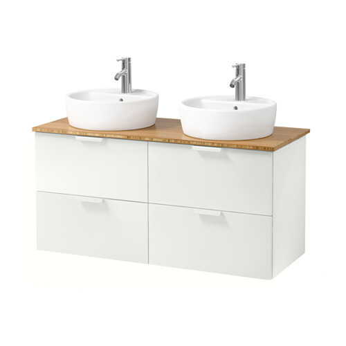 Double ceramic washbasin on wooden countertop over white base cabinet with four drawers.
