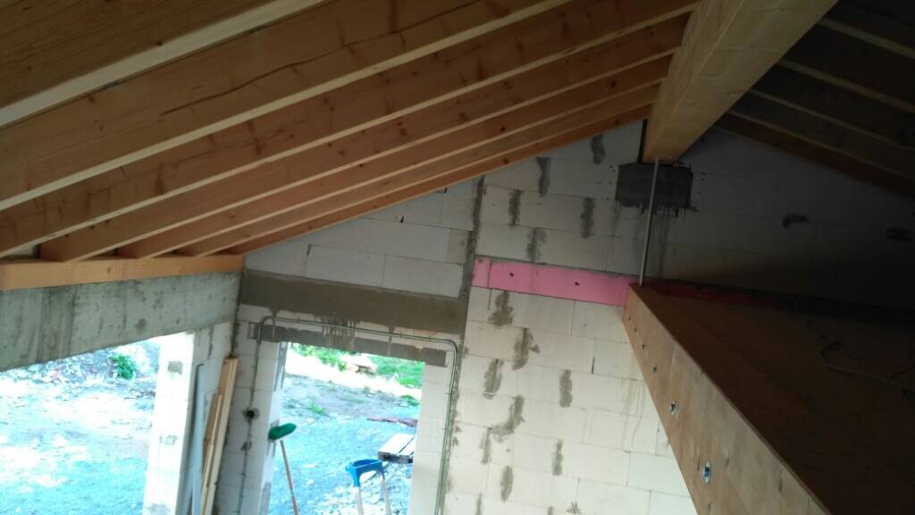 Rohbau Innenraum mit sichtbarem Dachstuhl, unverputzten BetonwÀnden und Bauwerkzeugen