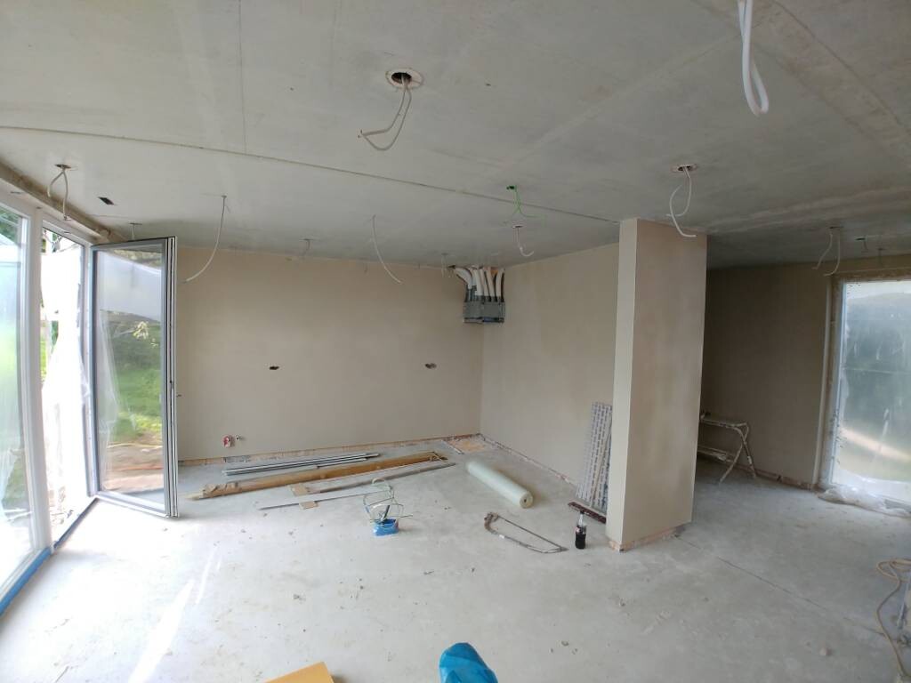 Renovation room: open ceiling, exposed cables, building materials and tools on the floor.