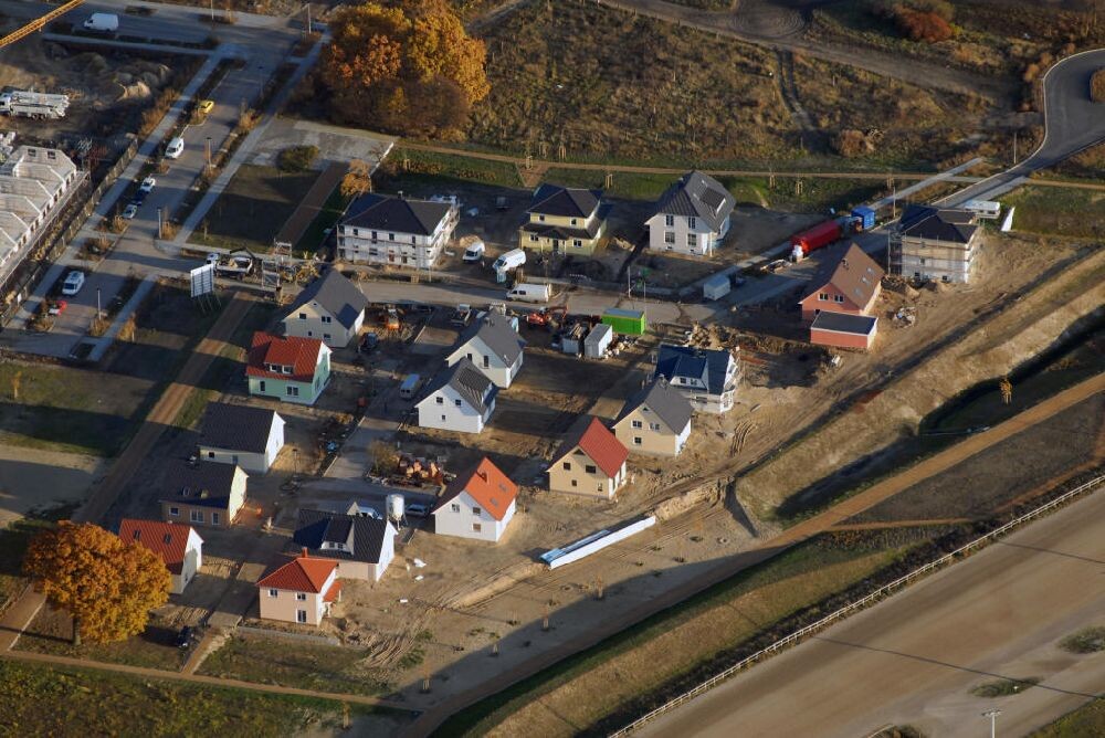Aerial view of a residential area with colorful roofs, streets, cars, and construction work along the waterfront.