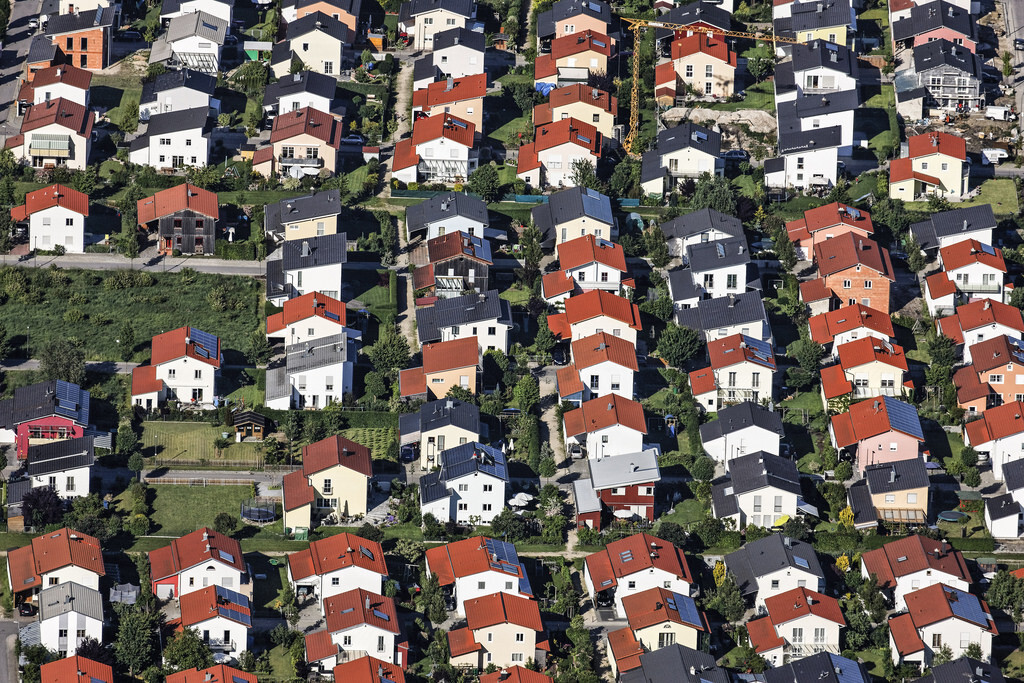 Aerial view of a residential area with many colorful houses and red, blue roofs.