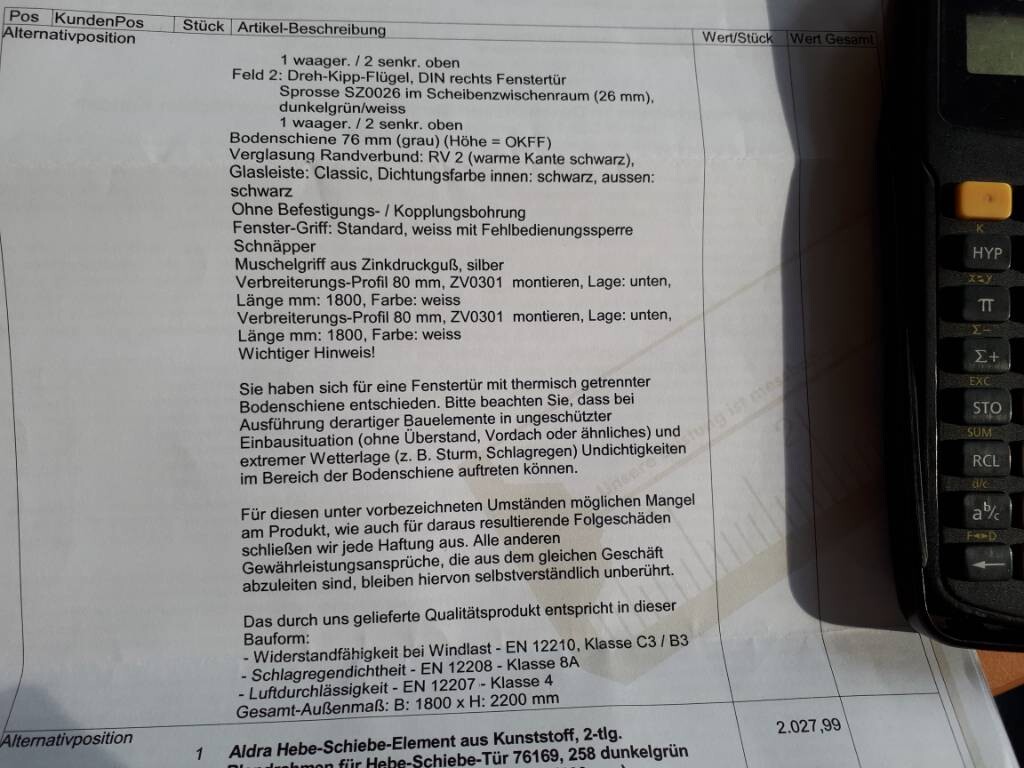 Bauunterlagen-Dokument mit Fenstergriffen und Montagespezifikationen neben Taschenrechner