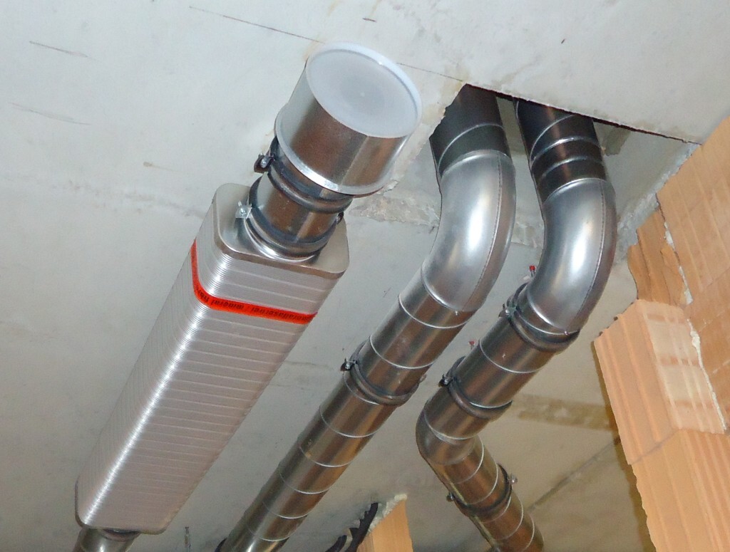 Metal ventilation ducts and a rectangular exhaust duct in the ceiling
