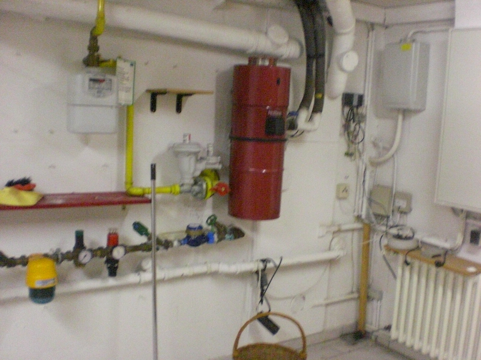 Basement room with heating system, piping, red boiler and radiators.