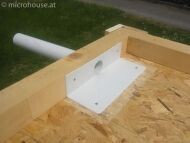 Construction site: timber frame with white installation box and pipe connection