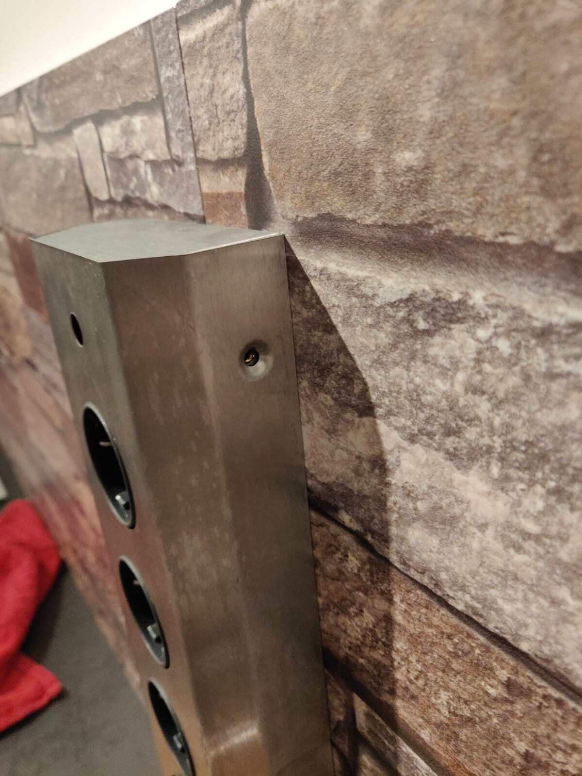 Metal wall box with round openings mounted on stone wall
