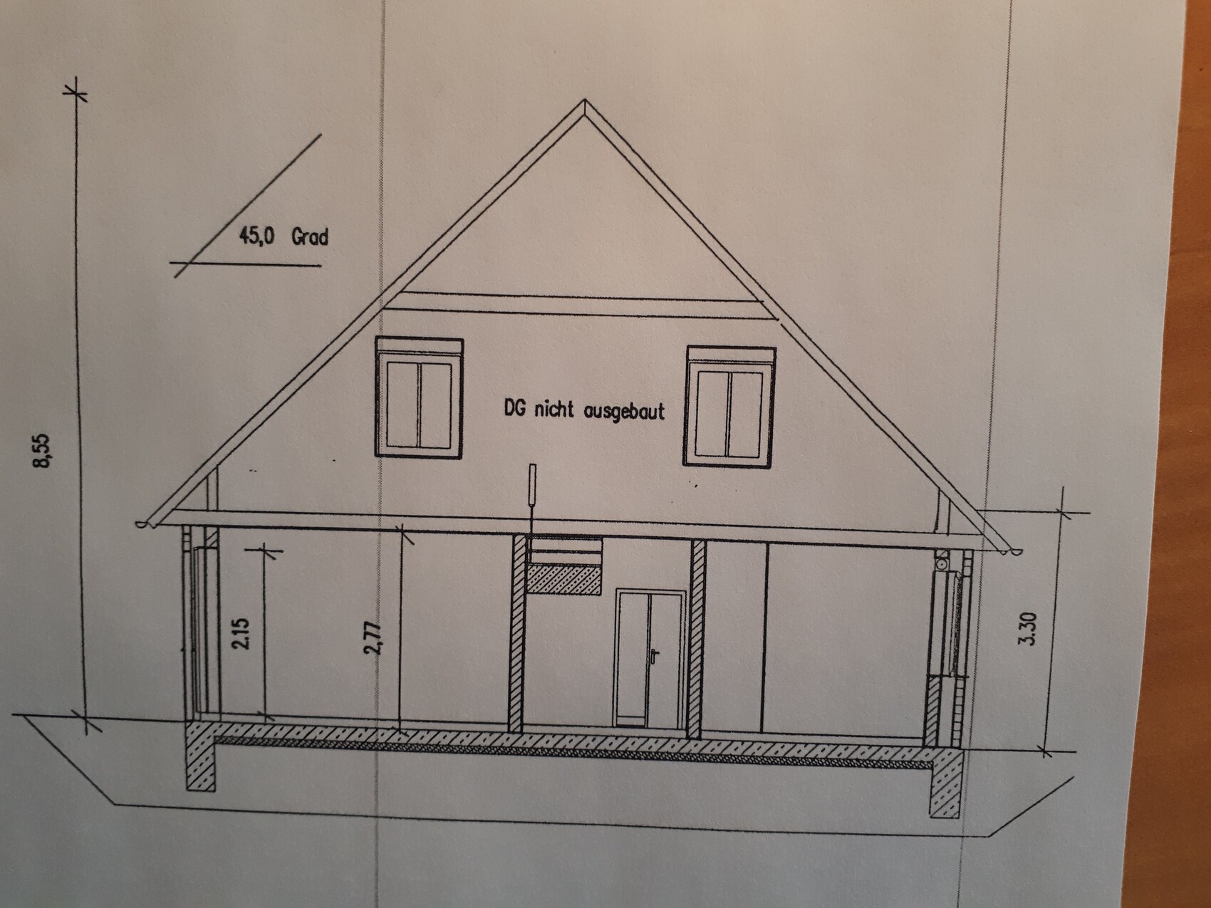 View of a house with gable roof, ground floor with door and two windows, attic not converted.