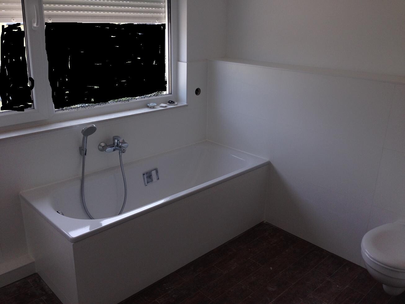 Bright bathroom with white bathtub, window and toilet, white tiles.