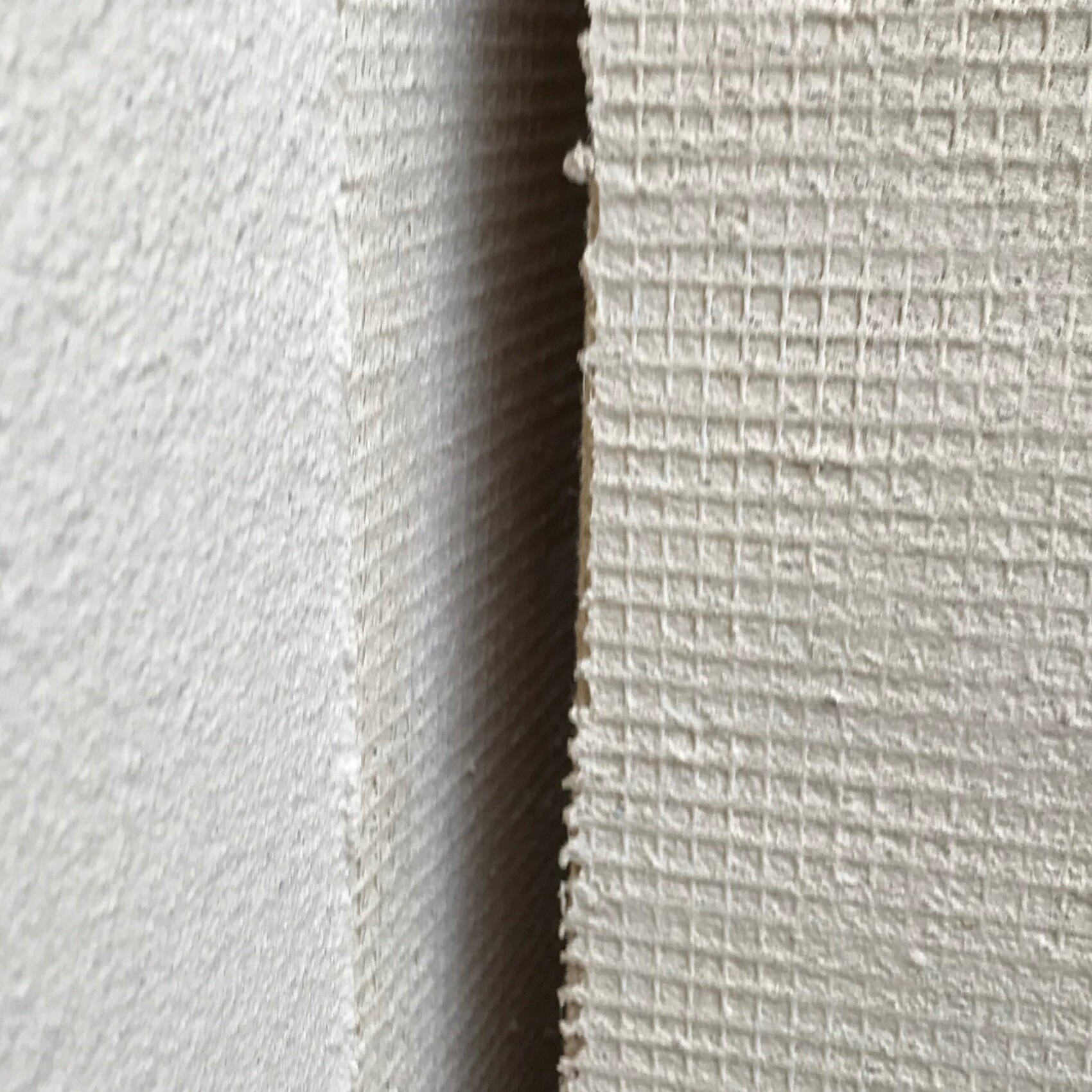 Close-up of a textured wall surface with a gap between two panels.