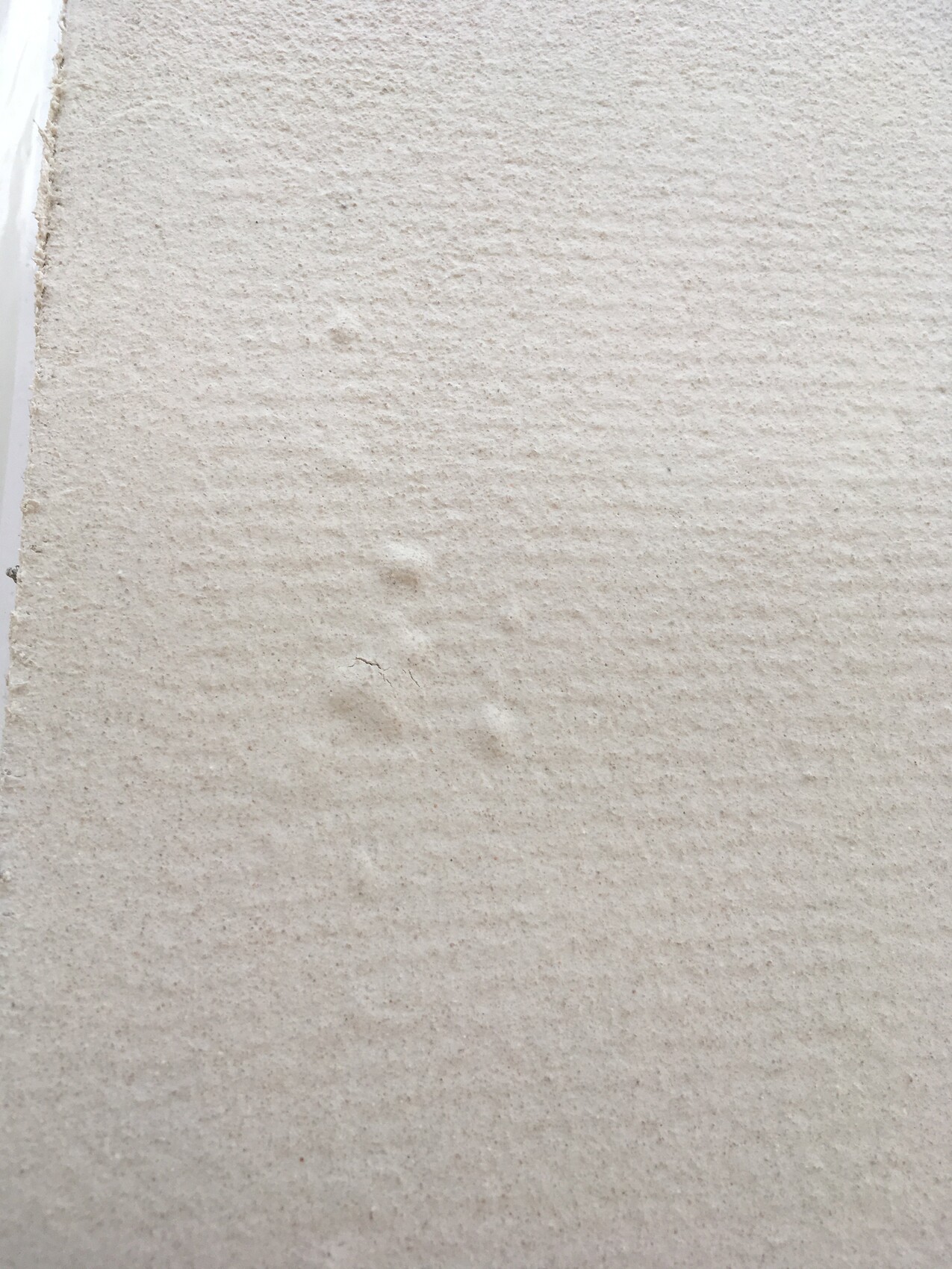 Close-up of a rough plastered wall surface with texture.