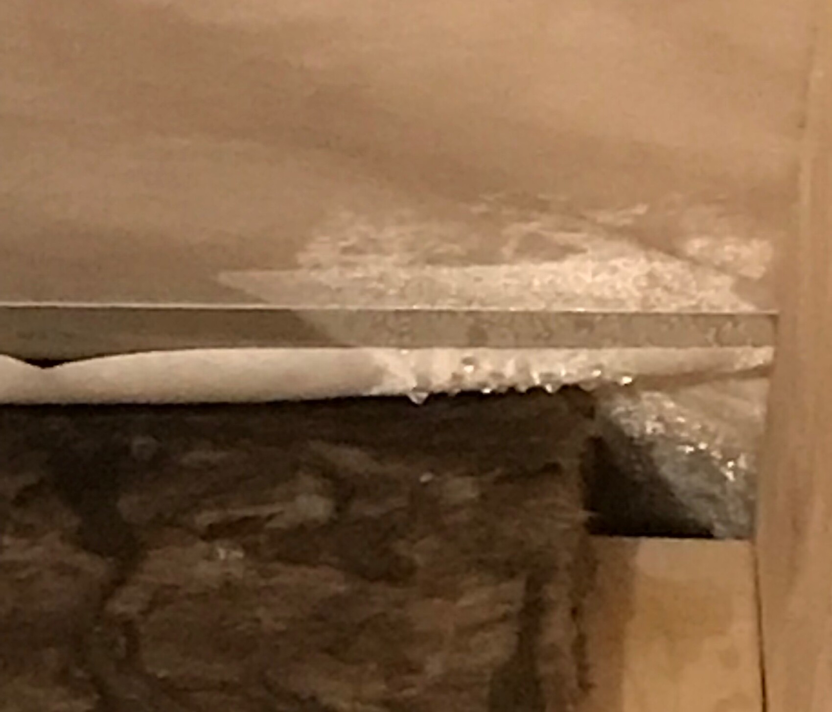 Close-up of a damaged wall with plaster flakes at the corner