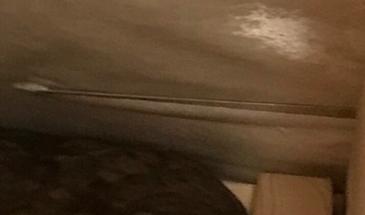 Dark, blurry close-up of a corner with furniture, barely visible
