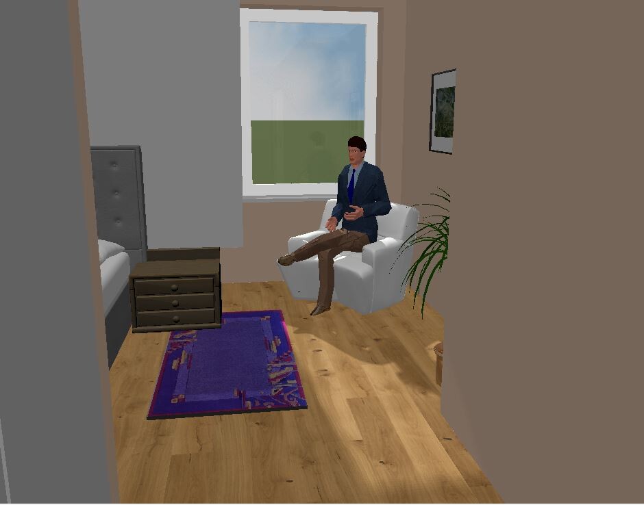 Man in suit sitting in a white armchair in the bedroom by the window.