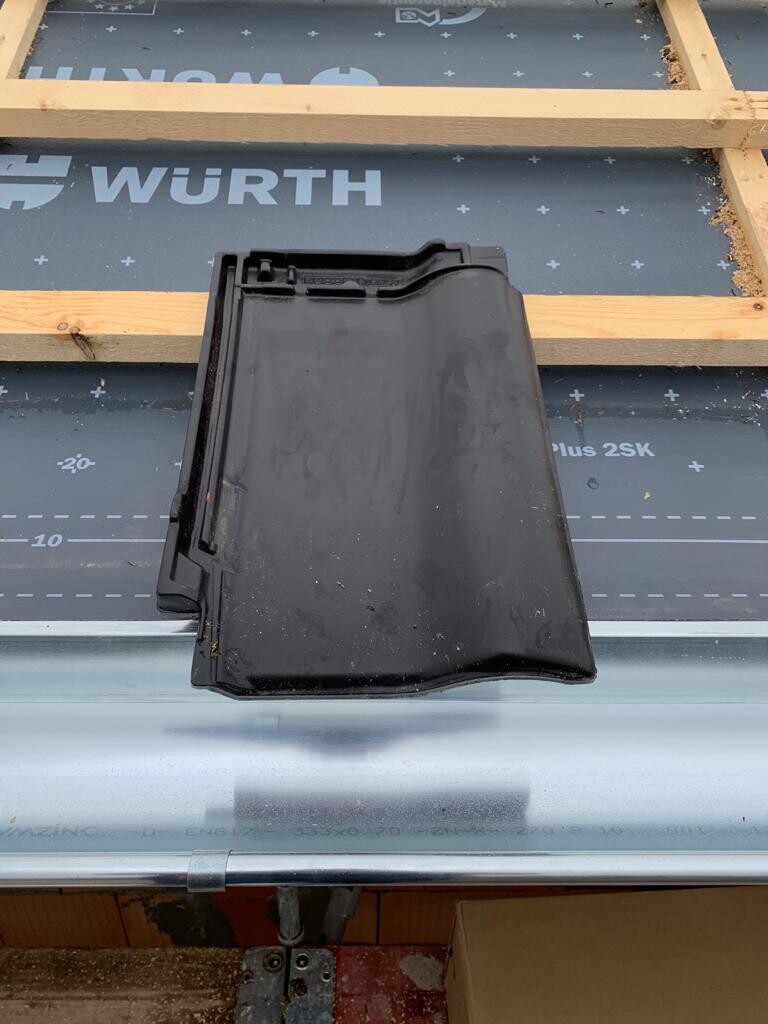 Black plastic roof component on underroof membrane with wooden battens; WÜRTH logo visible.