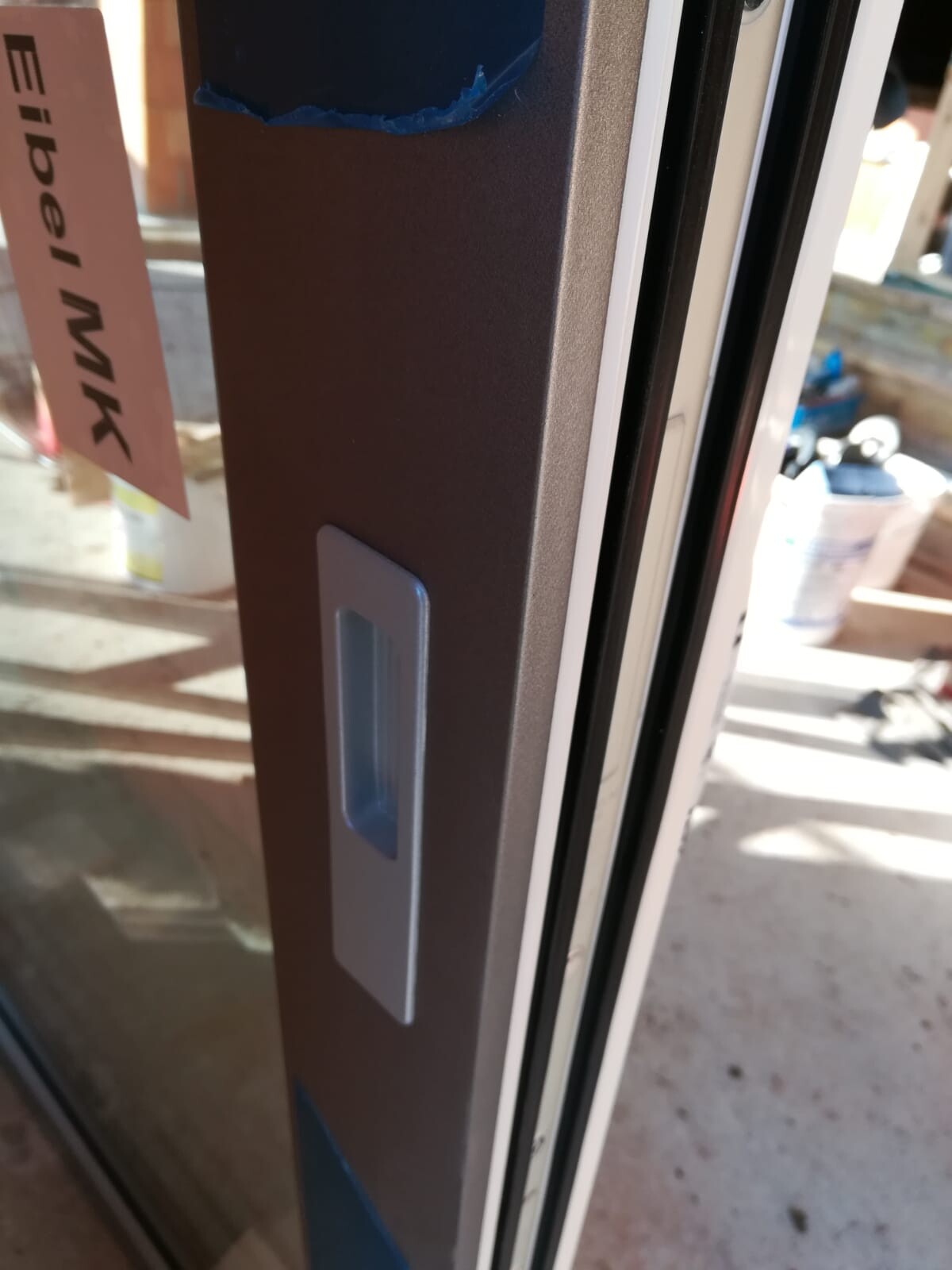 Close-up of a door frame with vertical handle recess and seal