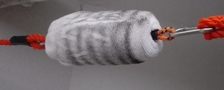 Fuzzy paint roller used in interior construction hanging from a rope in a room