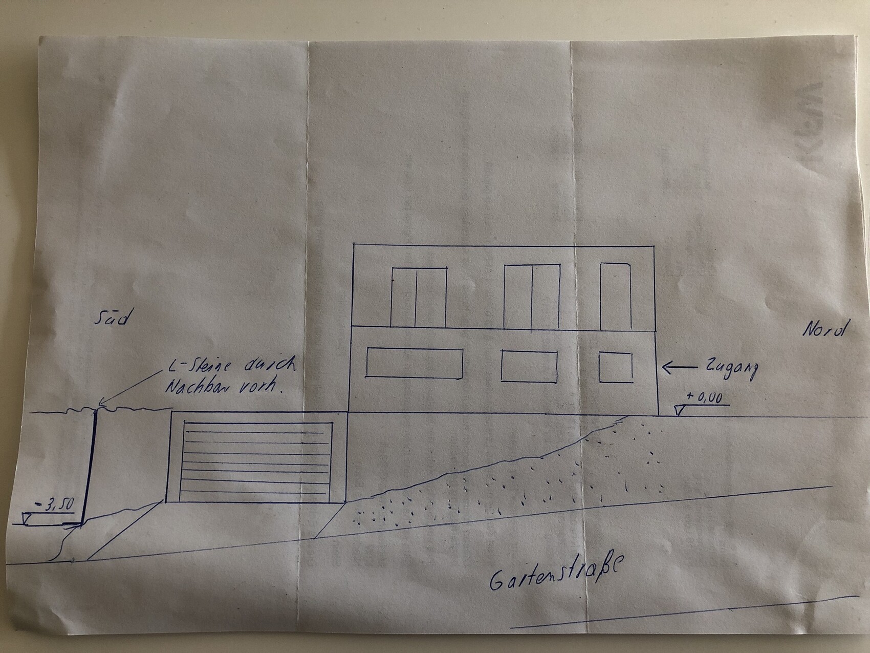 Sketch of a two-story house on a slope with garage at bottom left, entrance on right, garden street.