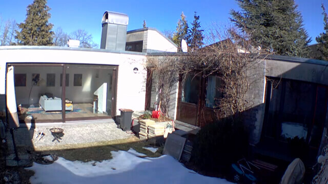 Exterior view of a house with terrace, garden, and construction wood in winter
