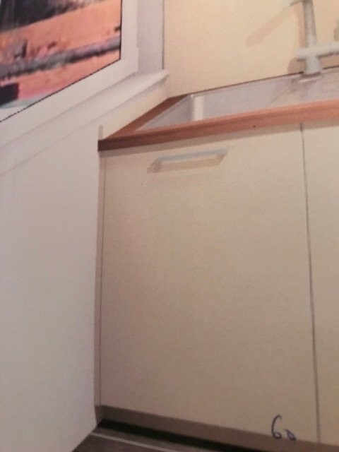 Bright kitchen area with white base cabinets, window on the left.