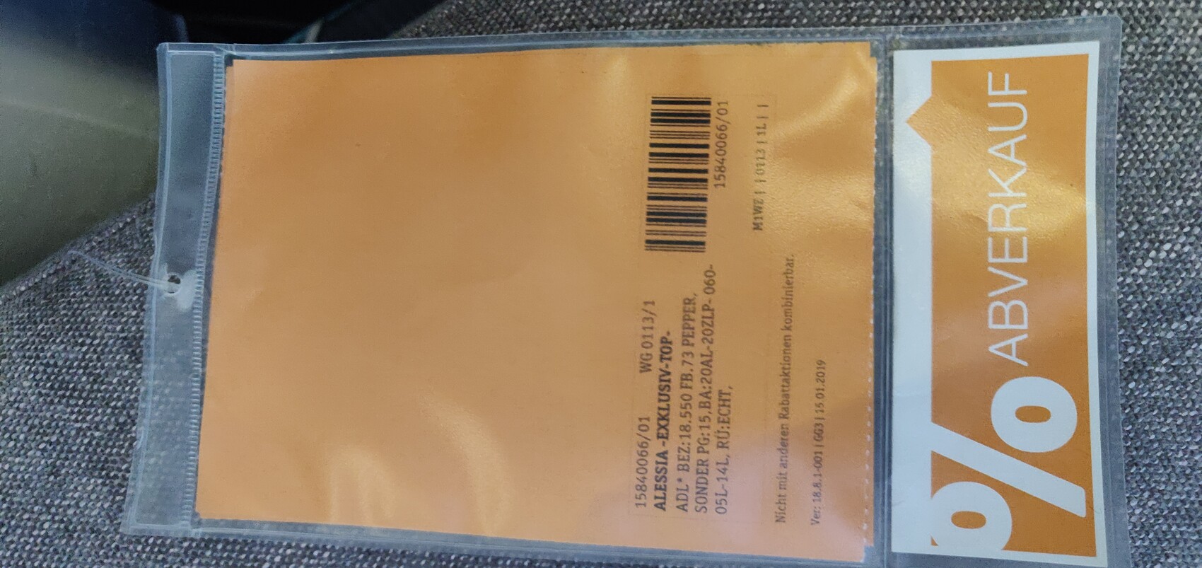 Plastic cardholder with orange label and barcode, CLEARANCE printed.