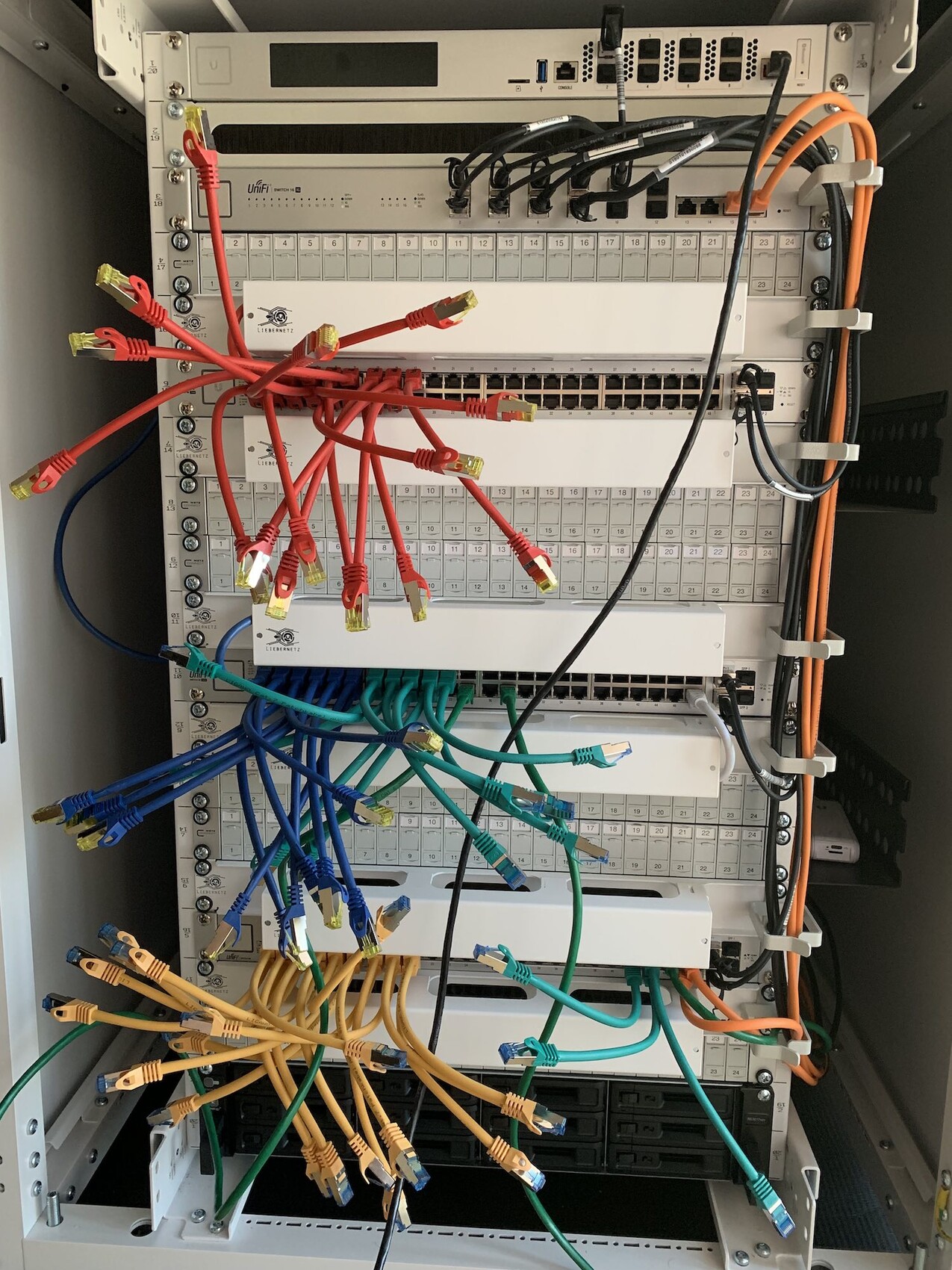 Serverrack with colorful network cables, patch panel, and switches in the data center