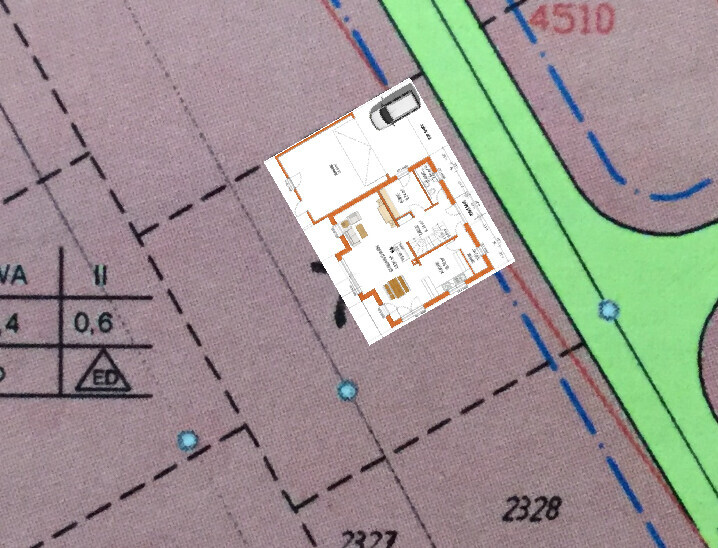 Small floor plan of a house placed on a colored city map with streets and green areas.