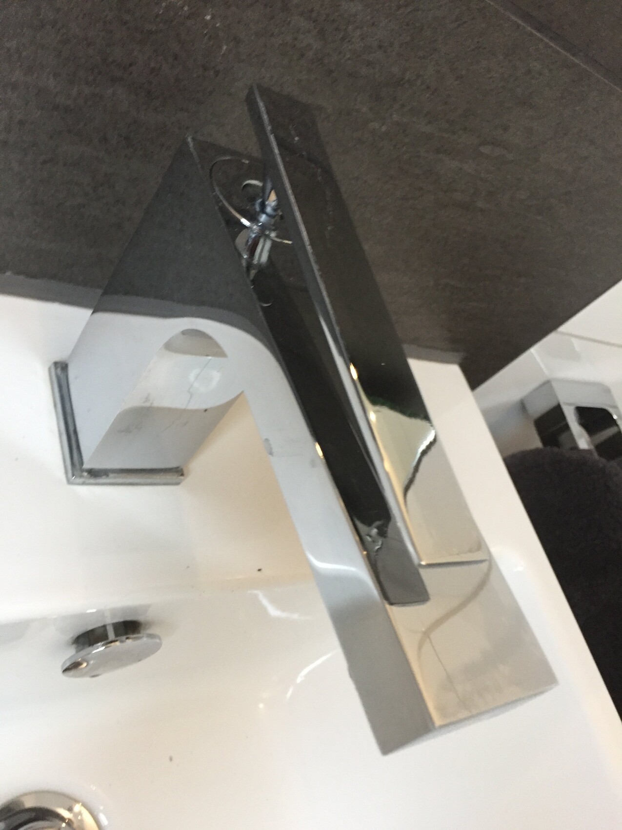 Modern shiny chrome faucet on washbasin, close-up of the faucet