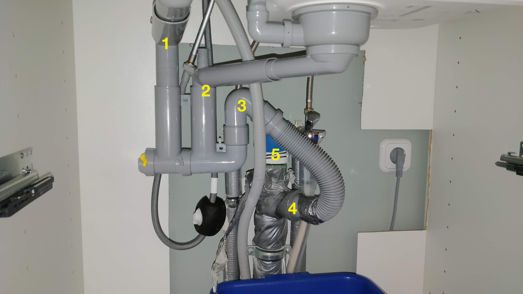 Visible drain pipes, siphon, and connection pipes under the sink