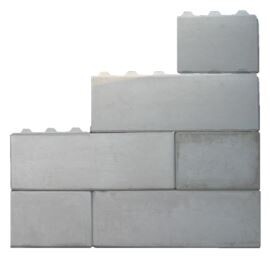 Mehrere graue Betonblöcke stapeln sich zu einer kleinen Mauer.