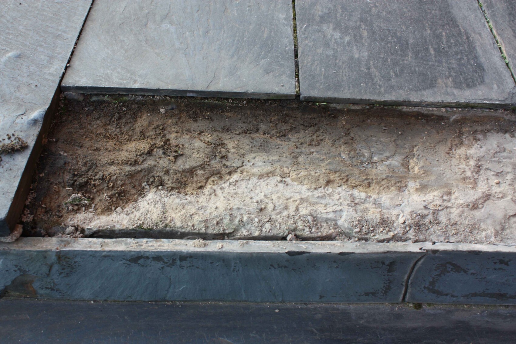 Close-up of concrete slabs and soil on a construction site, foundation work