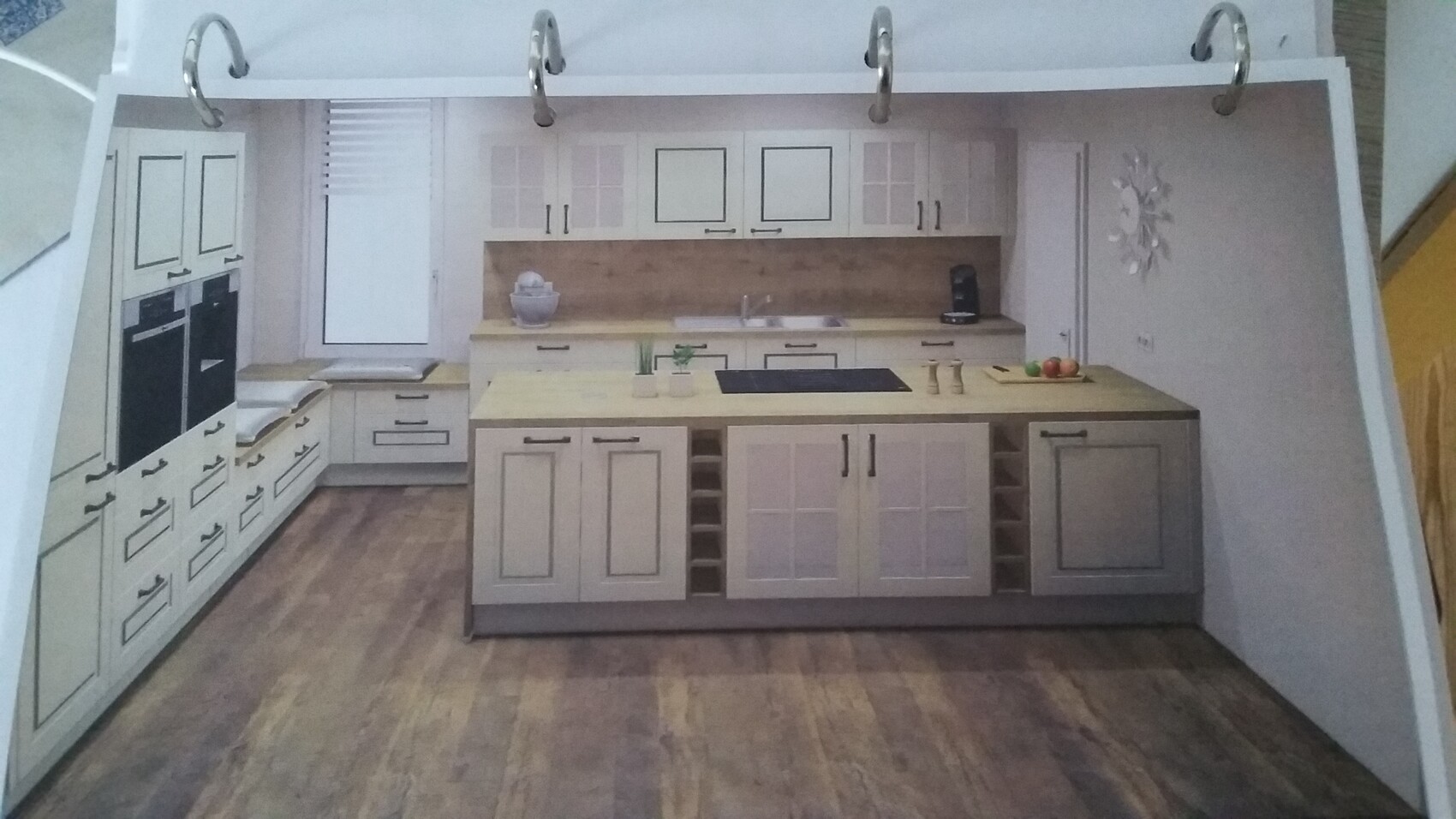 Bright kitchen with island; ovens on the left, sink in the middle, coffee station on the right, fruit on the island, wooden floor.