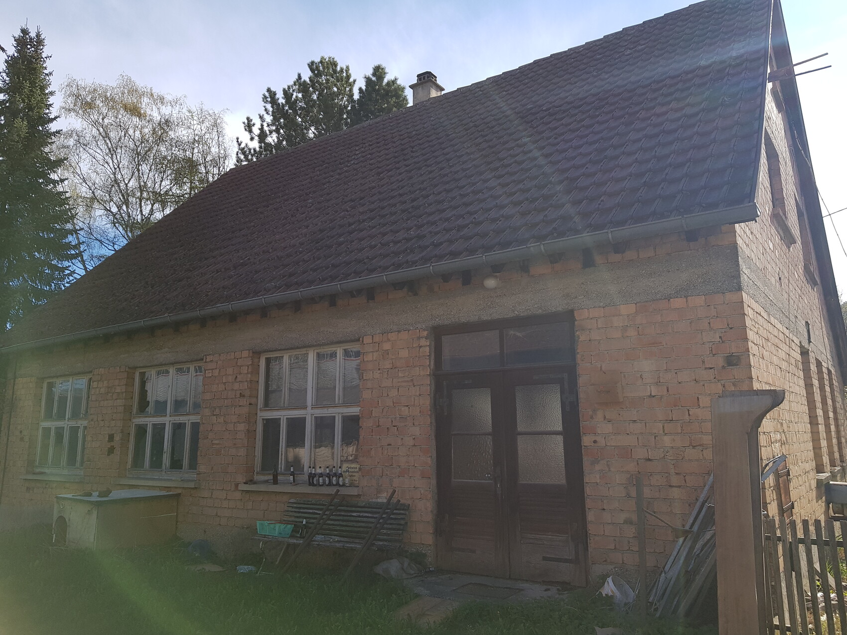 Exterior view of a brick house with a dark front door and roof tiles