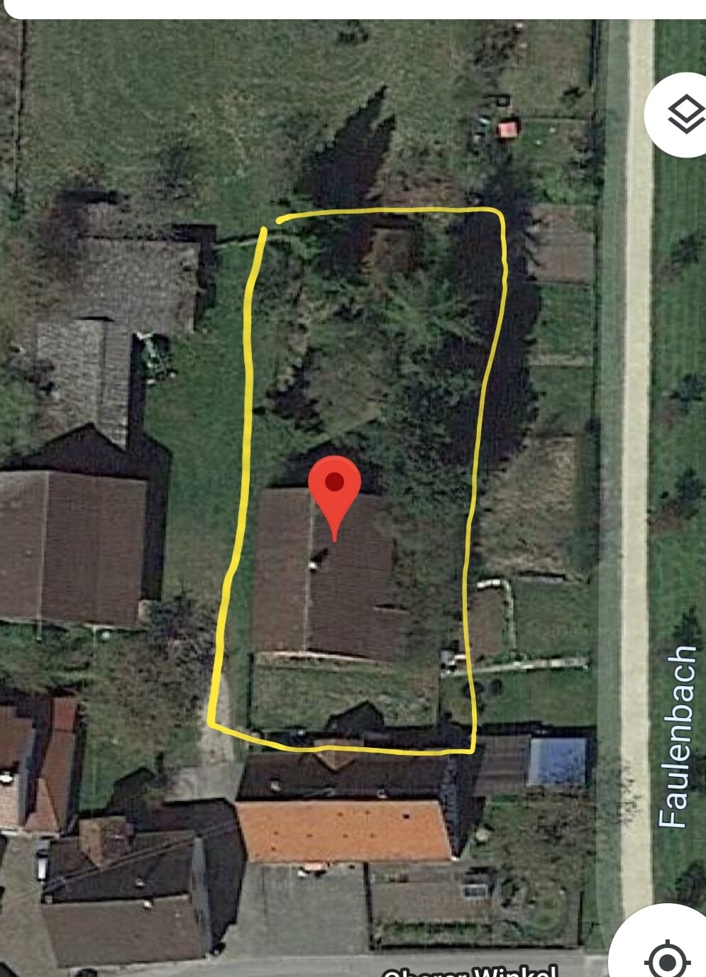 Satellite image of a residential plot with yellow marked boundary and red location marker