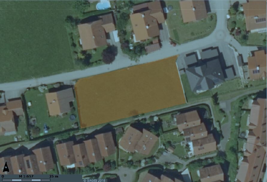 Aerial photo of a building plot in a residential area among houses.